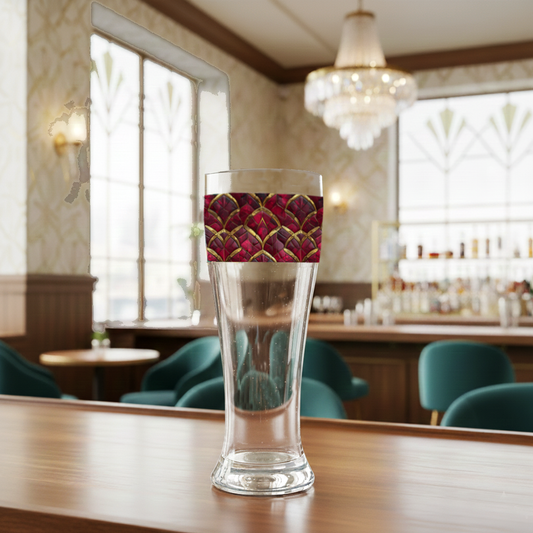 Crimson Jewels pilsner beer glass with a red and gold art deco design on a bar counter in a lounge setting