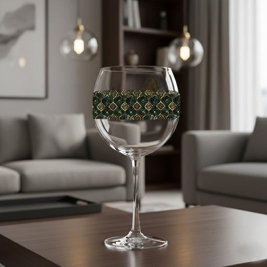 Malachite Enigma balloon wine glass with dark green and gold design on a table in a modern living room setting