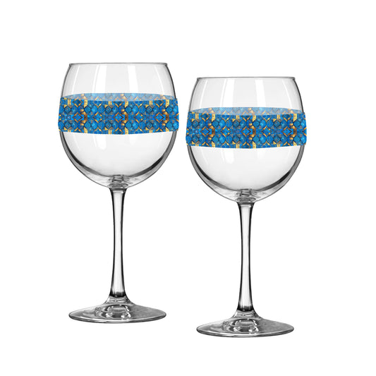Two balloon wine glasses with turqoise and gold geometric design on a white background