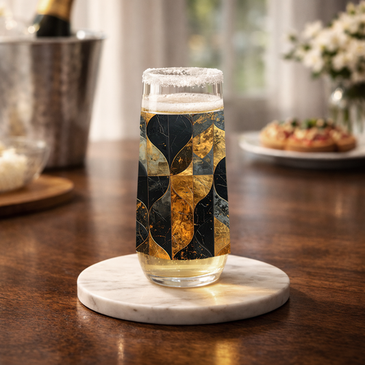 Aged Elegance stemless glass of champagne with charcoal and bronze decorative pattern on a table with champagne bucket and muffins in the background