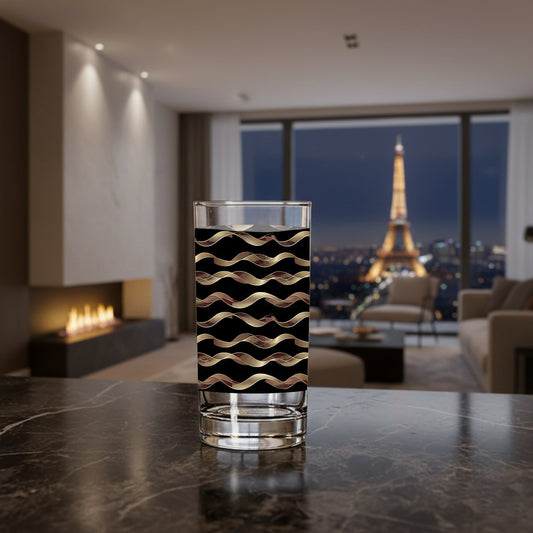 Liquid Gold highball glass in a black and gold wavy design on a marble counter in a modern living room with fireplace, sectional and city view of the Eiffel Tower in the background