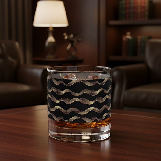 Liquid Gold whiskey glass with gold and black wavy design on a wooden table in a cozy room.