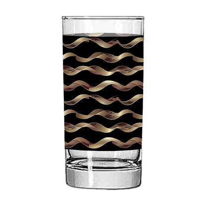 Clear glass tumbler with black and gold wavy pattern on white background