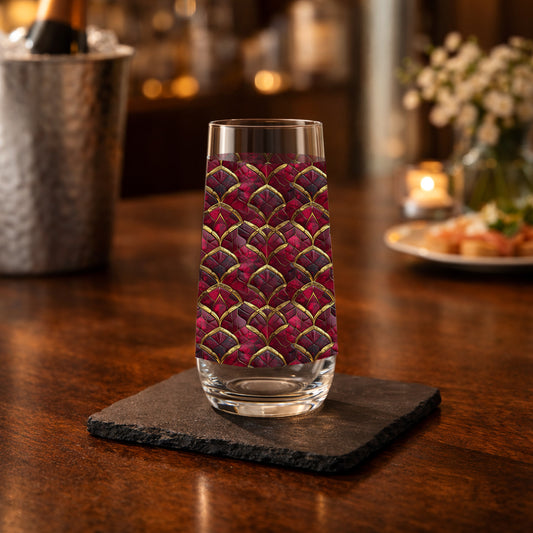 Crimson Jewels stemless champagne glass with a ruby and gold design on a table with a champagne bucket in the  background
