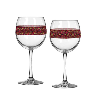 Two wine glasses with decorative red bands on a white background