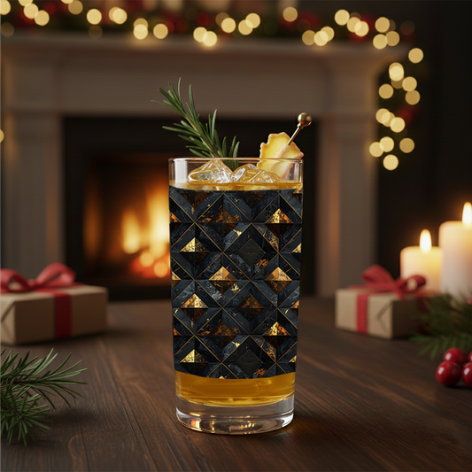 Gilded Decay highball glass and cocktail with charcoal and gold geometric pattern on a festive background with candles and presents.