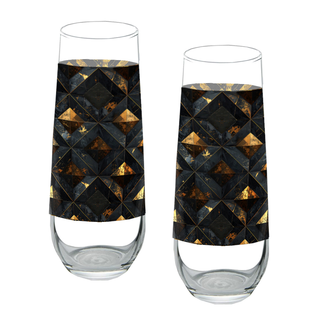 Two stemless champagne glasses with black and gold geometric pattern on a white background