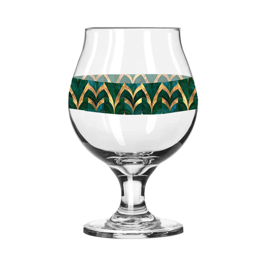 Belgian beer glass with green and gold geometric design on a white background