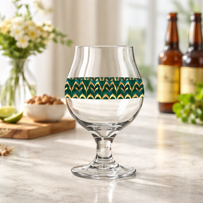 Emerald Royale Belgian beer glass with green and gold design on a bar counter in a art-deco inspired speakeasy setting.