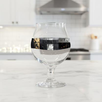 Fresco Fragments Belgian beer glass with black and gold pattern on a kitchen counter