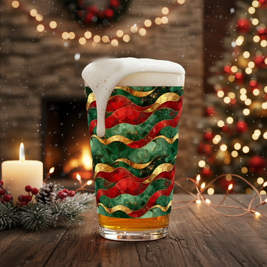 Royal Flux pint glass filled with beer and a wavy red, green, and gold pattern on a festive background with lights and candle.