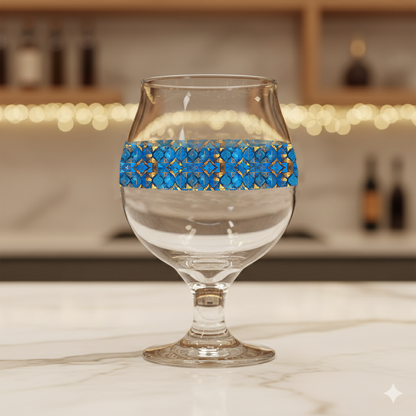 Moroccan Treasure Belgian glass of beer with blue and gold geometric design on a blurred bar background