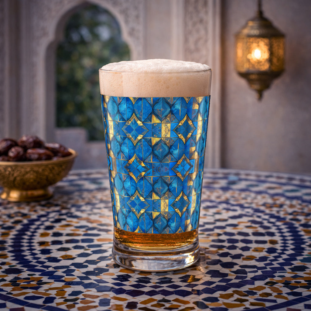 Moroccan Treasure pint glass with beer and foam head and a turquoise geometric design, sitting on table iin front of a fireplace