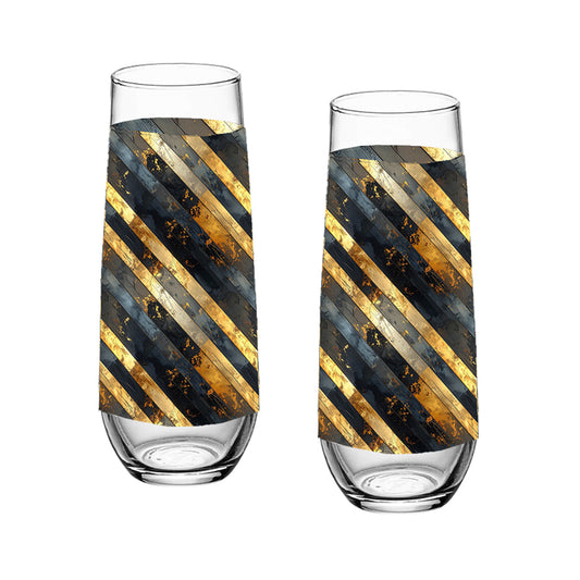 Two stemloess champagne glasses with black and gold striped design on a white background