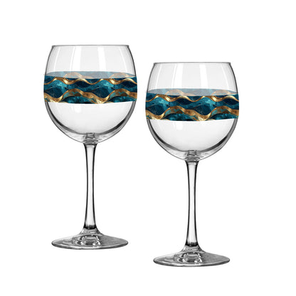Two wine glasses with blue and gold wave patterns on a white background