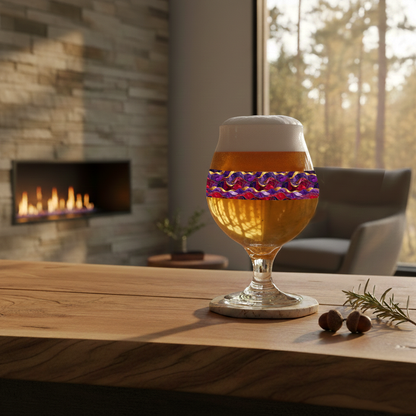 Fluid Marble Belgian glass in purple and gold pattern filled with pale beer on a wood surface with fireplace, chair, and large window in the background