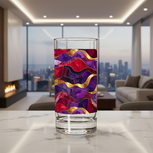 Fluid Marble highball glass with purple and gold design on a marble surface with a modern fireplace, sofa and large window with city view in the background