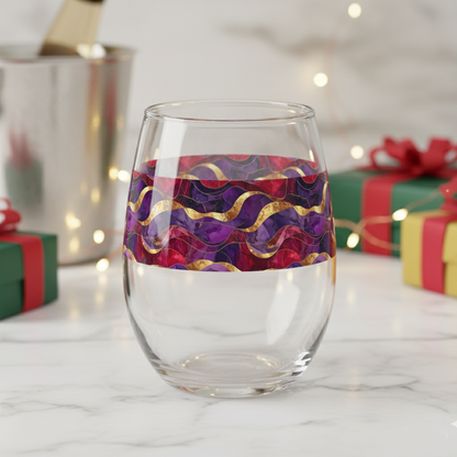 Fluid Marble stemless wine glass with purple and gold design on a white surface with holiday gift boxes in the background.