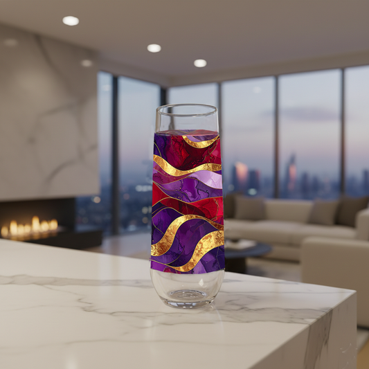 Fluid Marble stemless champagne glass with purple and gold design on a modern marble surface, and fireplace, sofa and large window with city view in background