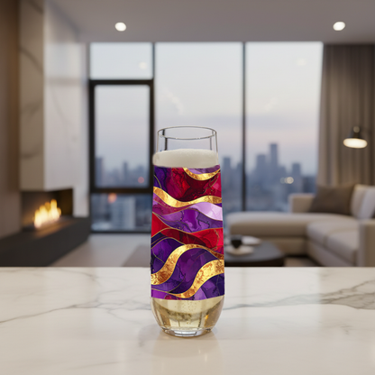 Fluid Marble stemless flute glass filled with champagne and in a purple and gold design on a marble countertop, and a modern fireplace, sofa and large window with city view in background