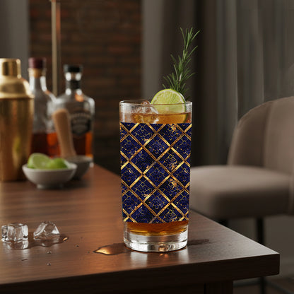 Regal Twilight highall glass with sapphire and gold wrap design, filled with cocktail and garnish sitting on a bar counter.