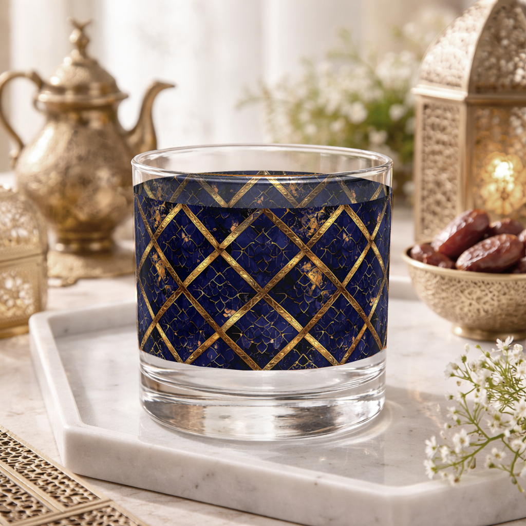 Regal Twilight rocks glass with sapphire and gold wrap design on a marble tray with decorative items.
