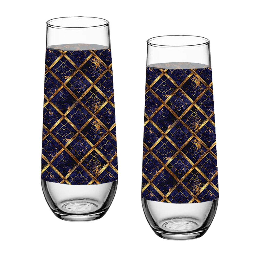 Two stemless champagne glasses with sapphire and gold wrap design on a white background