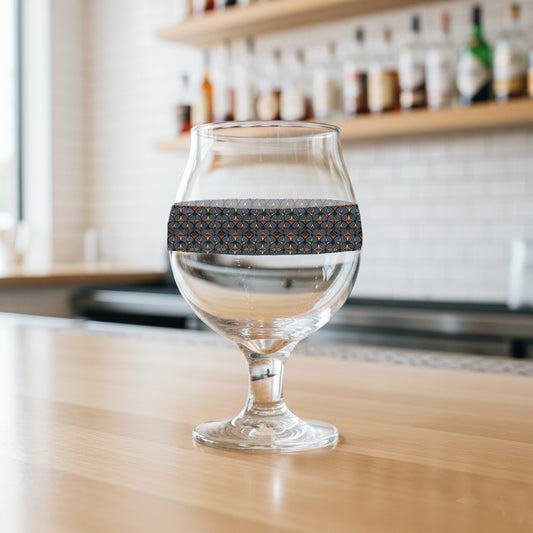 Burnished Slate Belgian beer glass with blue slate and copper design on a wooden surface, blurred bar background