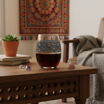 Burnished Slate stemless wine glass with slate blue and copper geometric pattern on a wooden table in a cozy living room.