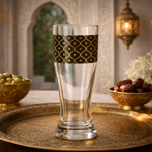 Midnight Marrakech pilsner beer glass with a black and gold design sitting on a tray in an elegant Moroccan setting