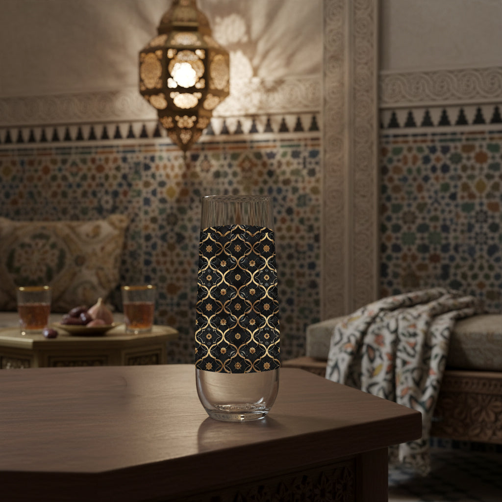 Midnight Marrakech stemless champagne glass with black and gold  deisgn on a wooden table in a room with colorful tiles and a lantern.