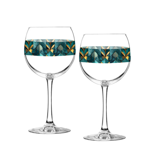 Two balloon wine glasses with teal and gold geometric patterned bands on a white background