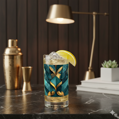 Gilded Patina highball glass with cocktail and a lemon wedge on a marble surface, with bar accessories in the background.
