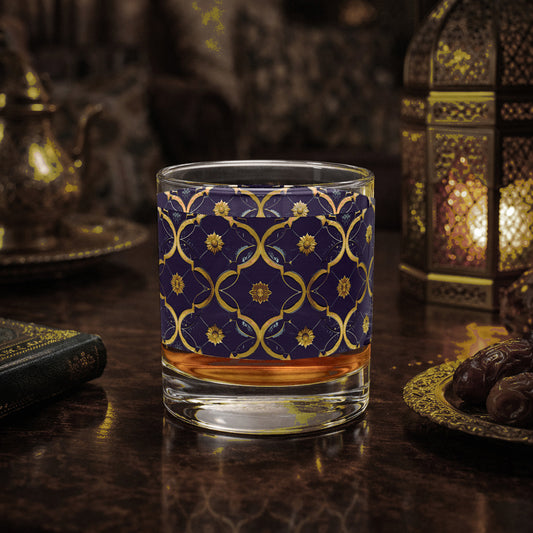 Midnight Marrakech rocks glass with a violet and gold design sitting on a wooden surface with decorative elements.